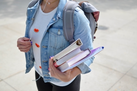 MMED Student carrying books