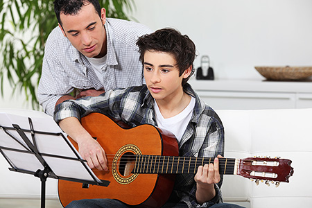 Guitar teacher with Masters in Music Education teaching student