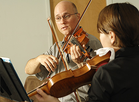 Teacher with Masters in Music Education instructing student on violin