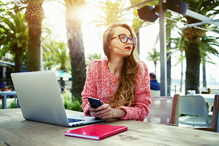 Student in Masters in Music Education online program at UF sitting at a laptop outside